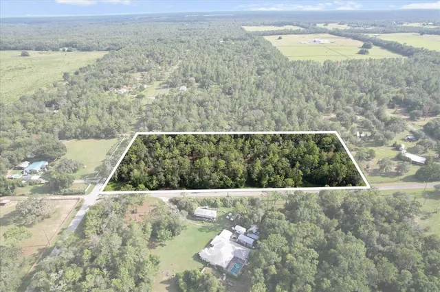 an aerial view of a houses with a yard and lake view