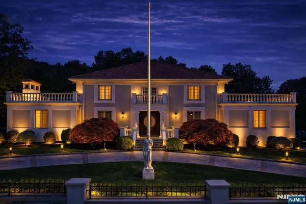 a front view of a house with street and trees