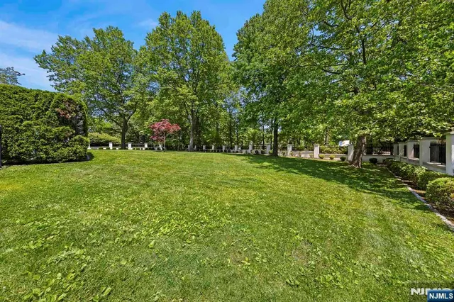 a large white kitchen with granite countertop a sink and white cabinets