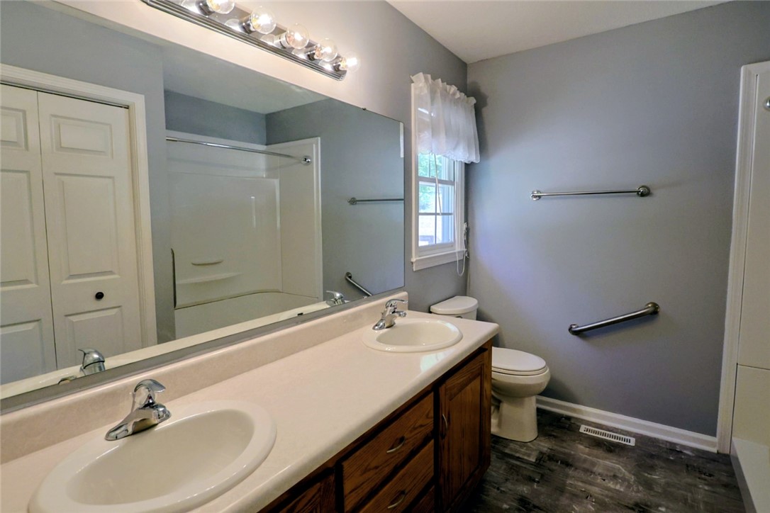 This clean and functional bathroom features a dual-sink vanity and practical fixtures.