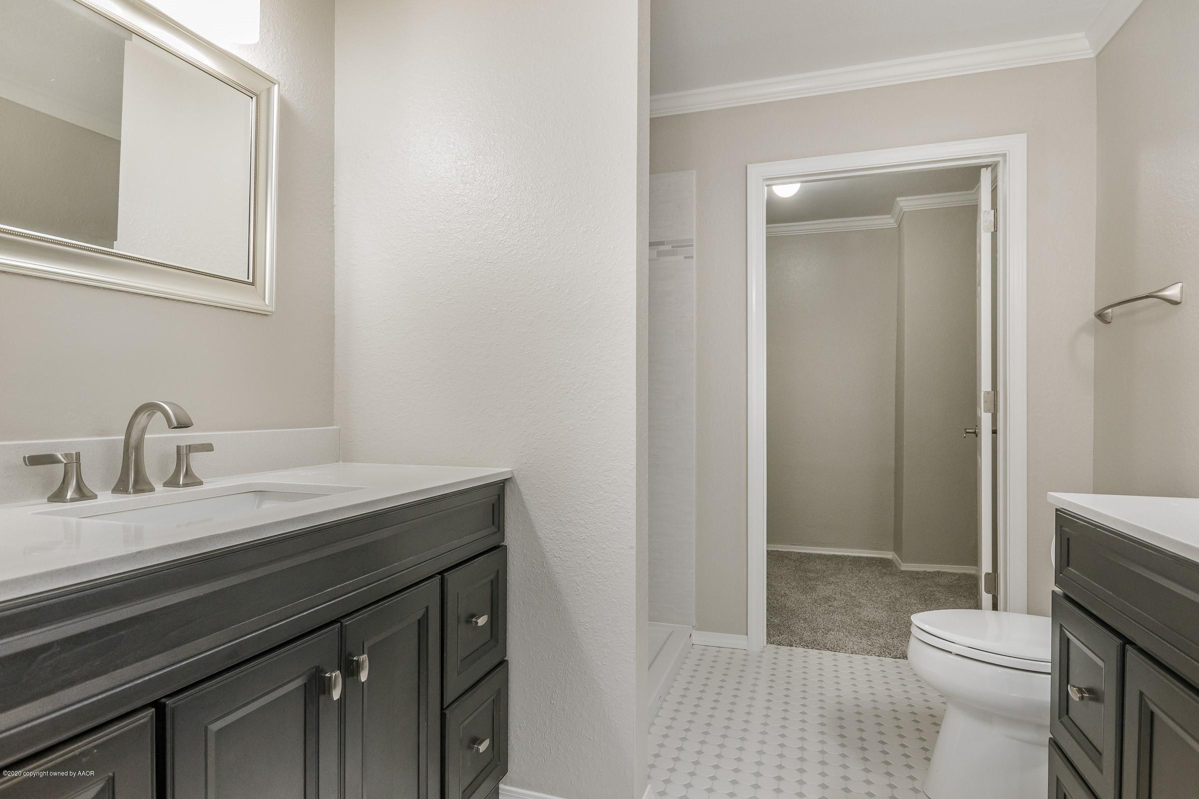 5135 Bowie Street Amarillo, TX 79110 - Photo 15 of 24 a bathroom with a sink a toilet a shower and a mirror