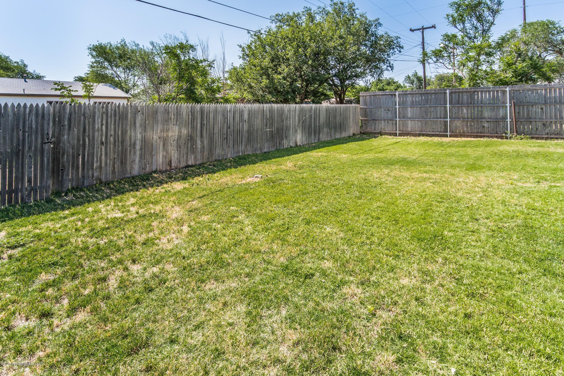 5135 Bowie Street Amarillo, TX 79110 - Photo 22 of 24 a view of a backyard with a small fence and trees