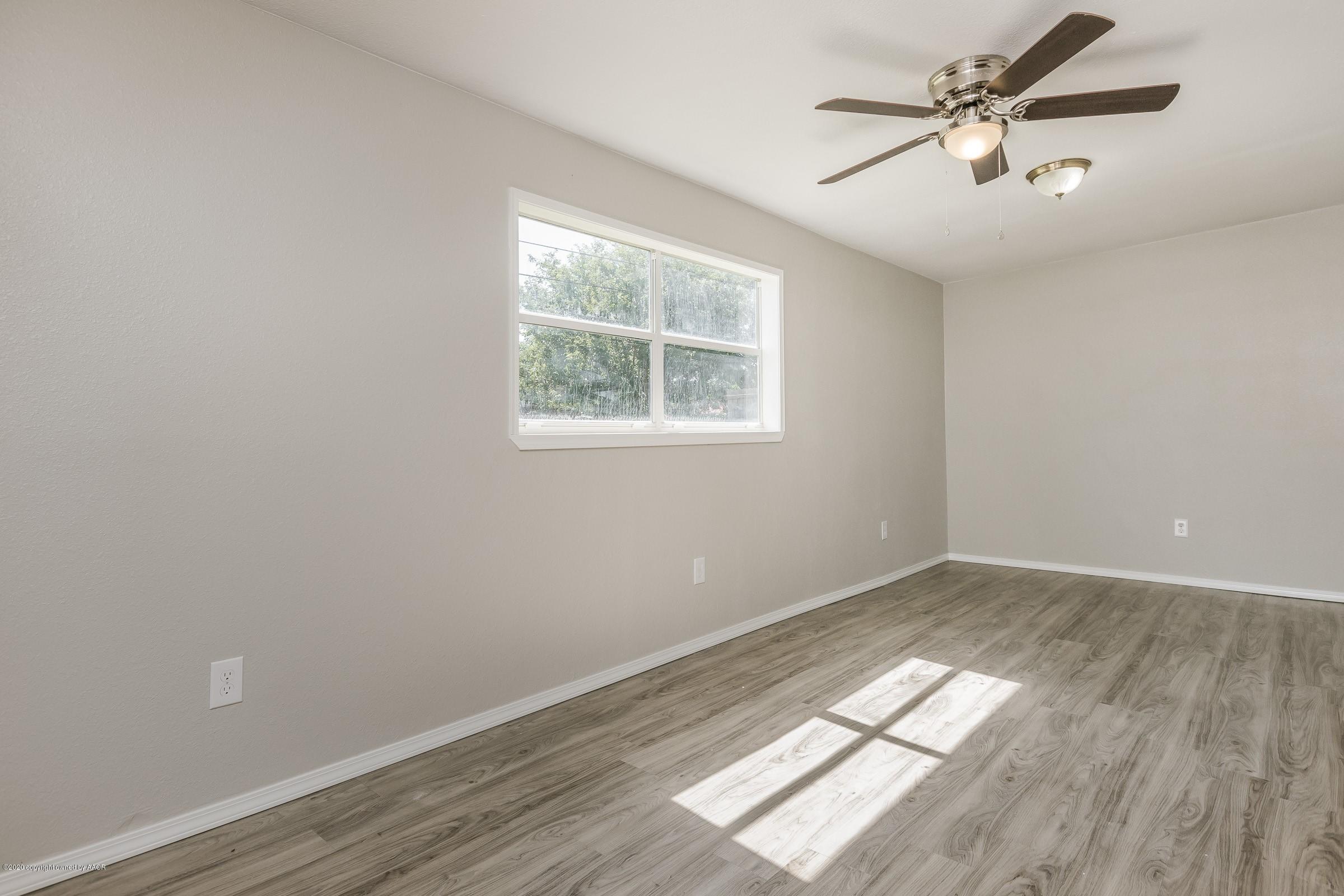 5135 Bowie Street Amarillo, TX 79110 - Photo 5 of 24 an empty room with wooden floor and windows