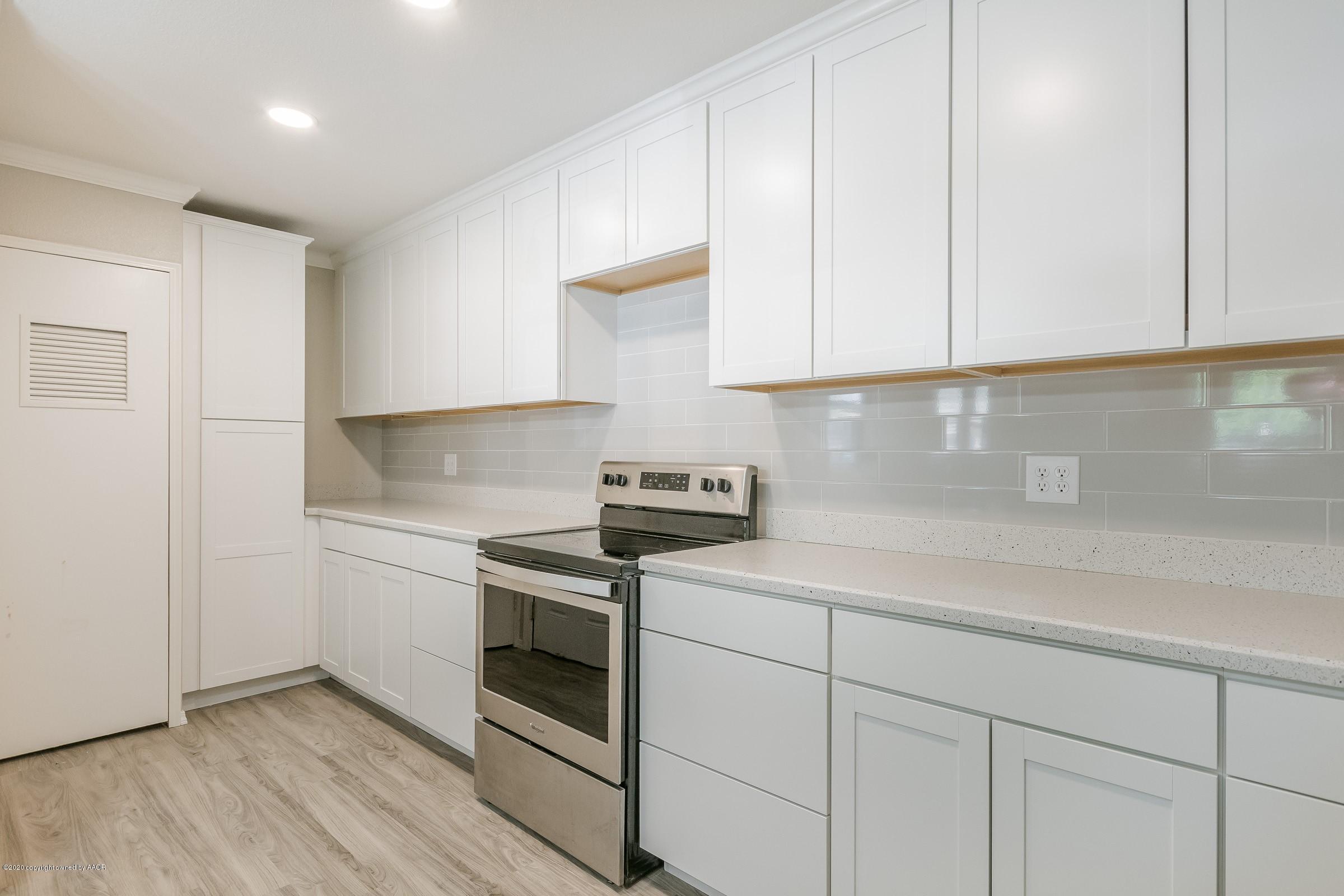 5135 Bowie Street Amarillo, TX 79110 - Photo 7 of 24 a kitchen with white cabinets and white appliances