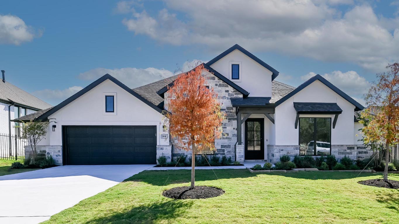View of front of property featuring stone siding, stucco siding, concrete driveway, and a front lawn