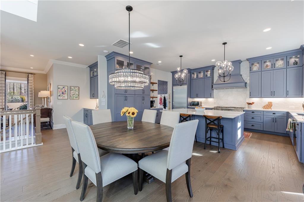 3085 Gray Hawk Lane Roswell, GA 30076 - Photo 15 of 99 a view of a dining room and livingroom with furniture wooden floor a rug a fireplace and a chandelier