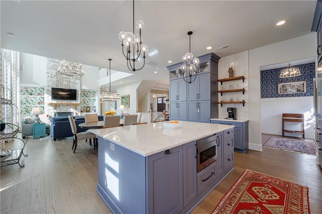 3085 Gray Hawk Lane Roswell, GA 30076 - Photo 22 of 99 a large kitchen with stainless steel appliances granite countertop a stove oven a dining table and chairs with wooden floor