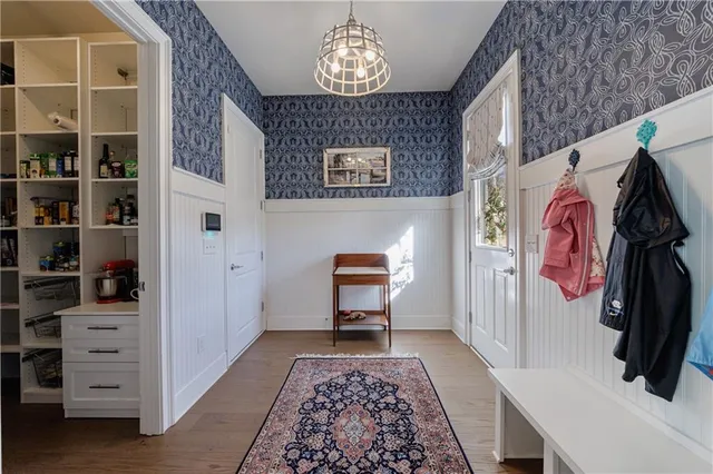 a bedroom with a bed a chandelier and a large window