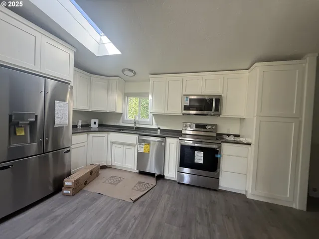 a kitchen with granite countertop a refrigerator stove and microwave