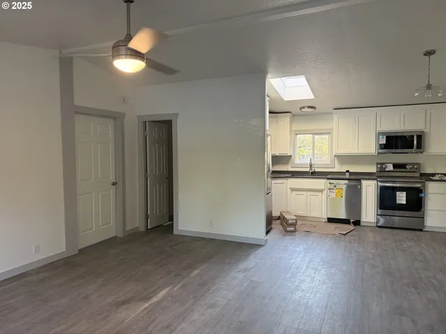 a kitchen with a refrigerator and a stove top oven