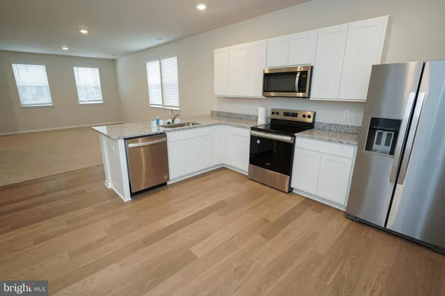 a kitchen with granite countertop a refrigerator stove and microwave
