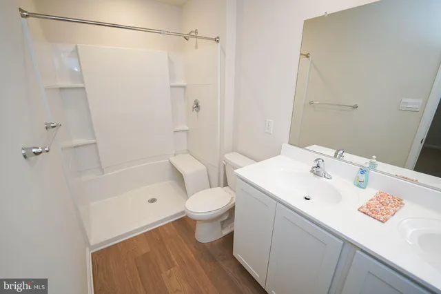 a bathroom with a sink a toilet and shower