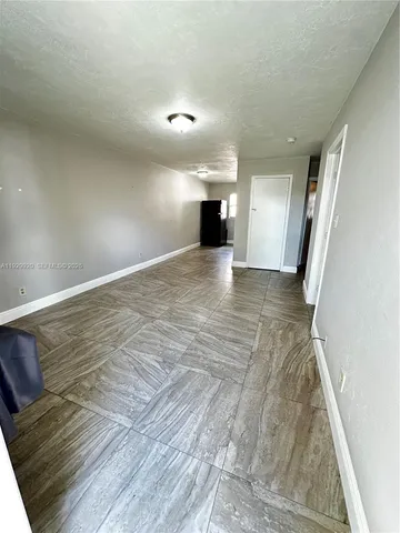 a view of empty room with wooden floor and window
