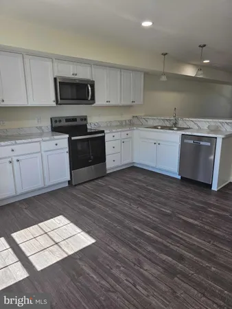 a large kitchen with a stove top oven and sink