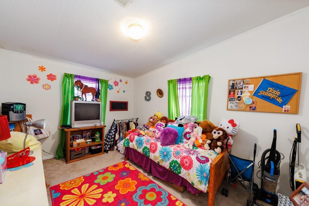 474 Hanging Tree Road Bowie, TX 76230 - Photo 11 of 27 a bedroom with toys and a flat screen tv