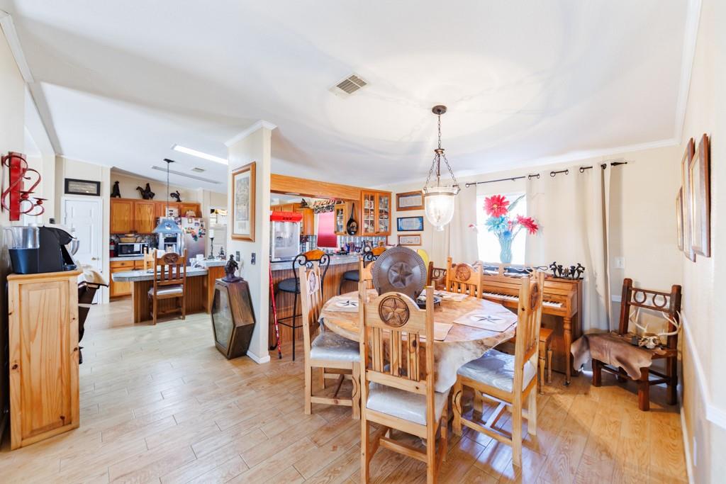 474 Hanging Tree Road Bowie, TX 76230 - Photo 8 of 27 a view of a dining room with furniture and a chandelier