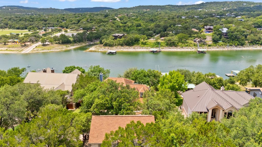10800 Beach Road Leander, TX 78641 - Photo 33 of 39 An aerial perspective reveals a serene lakefront community nestled amidst lush green hills.