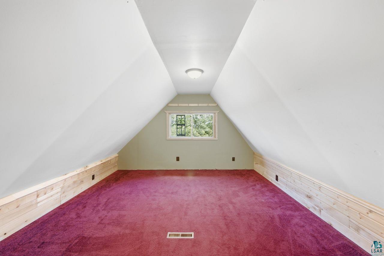 65889 Old County Road Marengo, WI 54855 - Photo 16 of 44 Sloped ceiling design, recessed window, wall-mounted light fixture, and wood-finish paneling