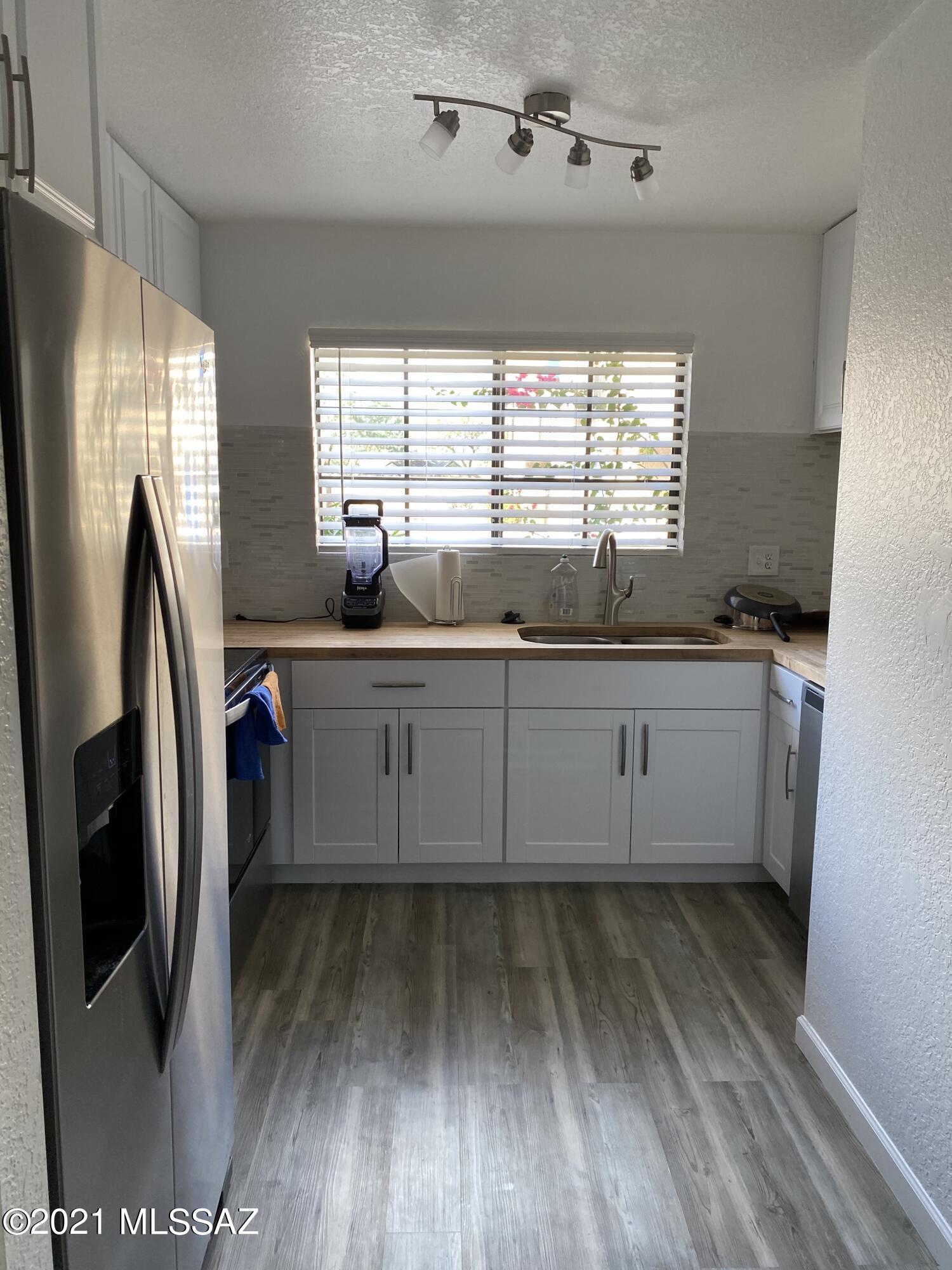 236 East Pastime Road Tucson, AZ 85705 - Photo 11 of 20 a kitchen with stainless steel appliances granite countertop a sink a refrigerator and wooden floor