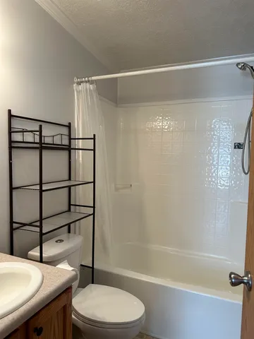 a kitchen with stainless steel appliances granite countertop a refrigerator a stove a sink dishwasher and white cabinets with wooden floor