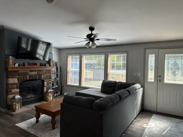 a living room with furniture a flat screen tv and a fireplace