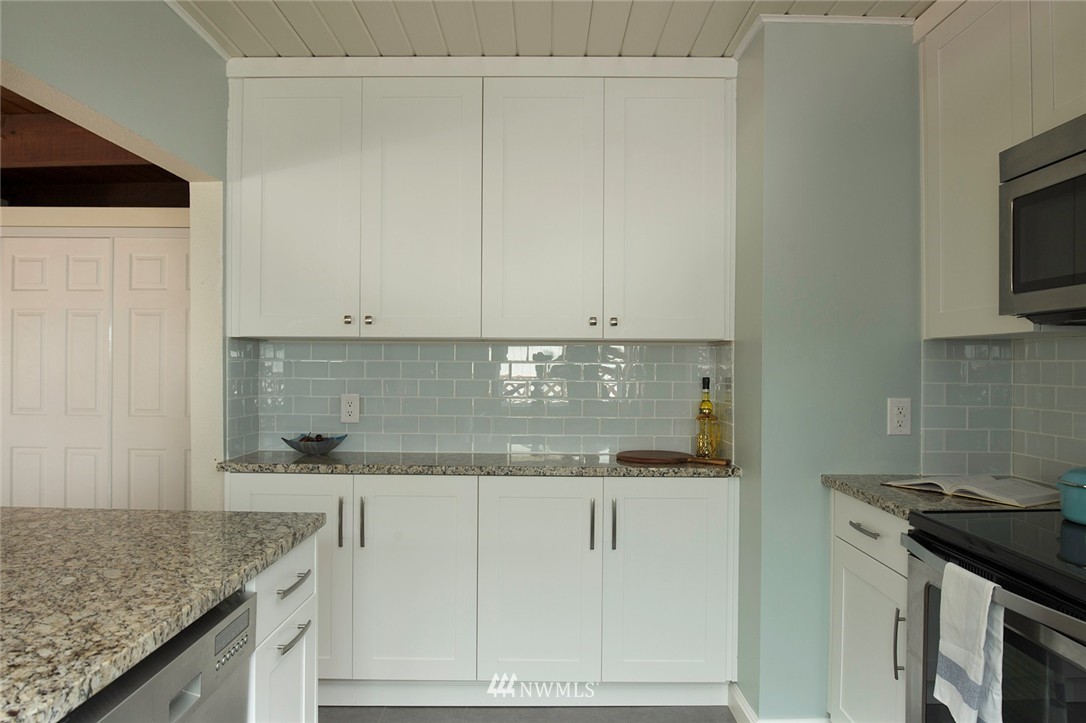 736 North 88th Street Seattle, WA 98103 - Photo 15 of 17 a kitchen with granite countertop white cabinets and a sink