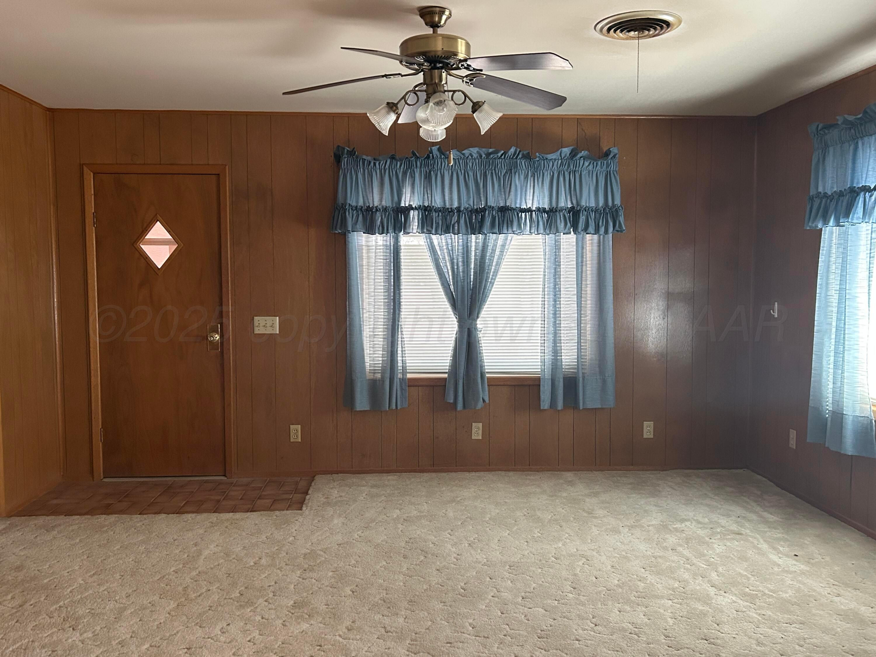 102 Willow Street Lipscomb, TX 79056 - Photo 12 of 34 an empty room with a window and chandelier fan