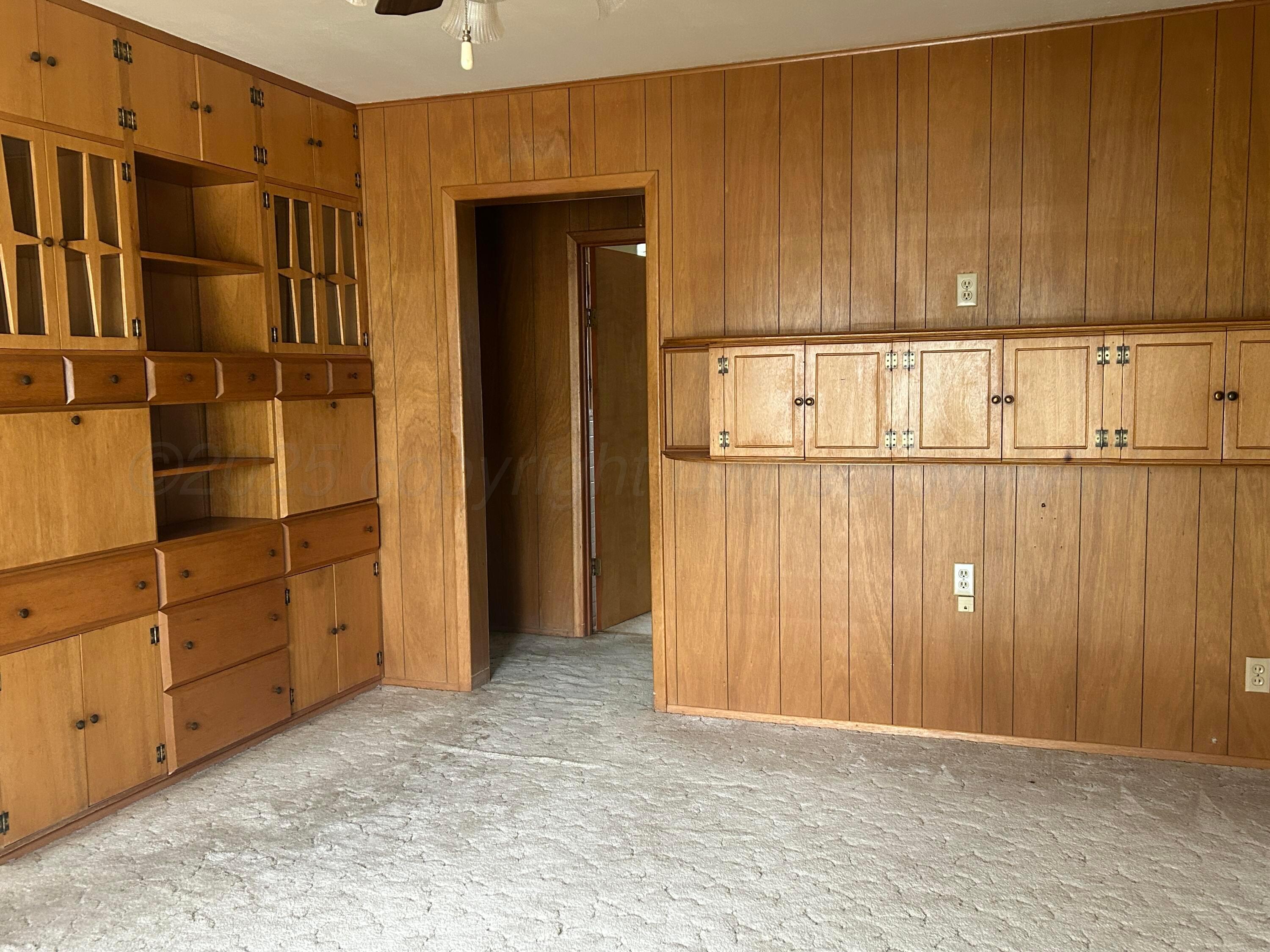 102 Willow Street Lipscomb, TX 79056 - Photo 15 of 34 a view of a kitchen with an empty space and wooden shelves