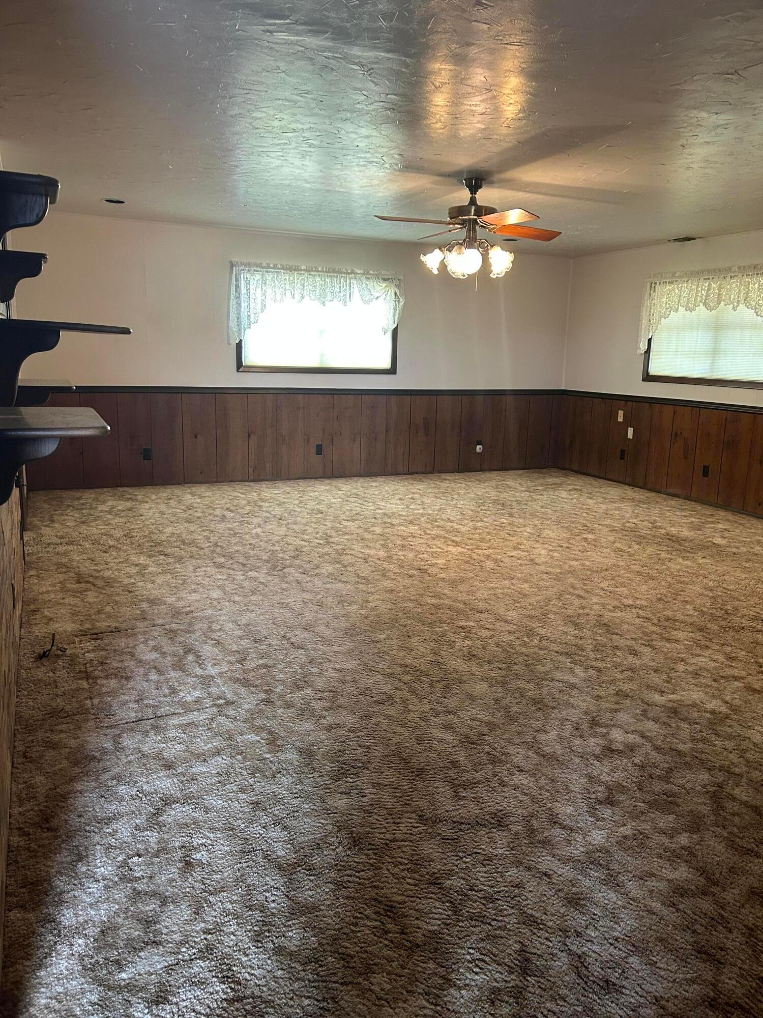 102 Willow Street Lipscomb, TX 79056 - Photo 28 of 34 an empty room with chandelier fan and windows