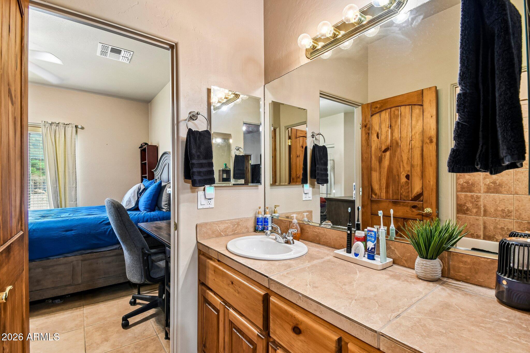 1547 North Val Vista Road Apache Junction, AZ 85119 - Photo 23 of 59 a bathroom with a granite countertop sink a mirror and shower