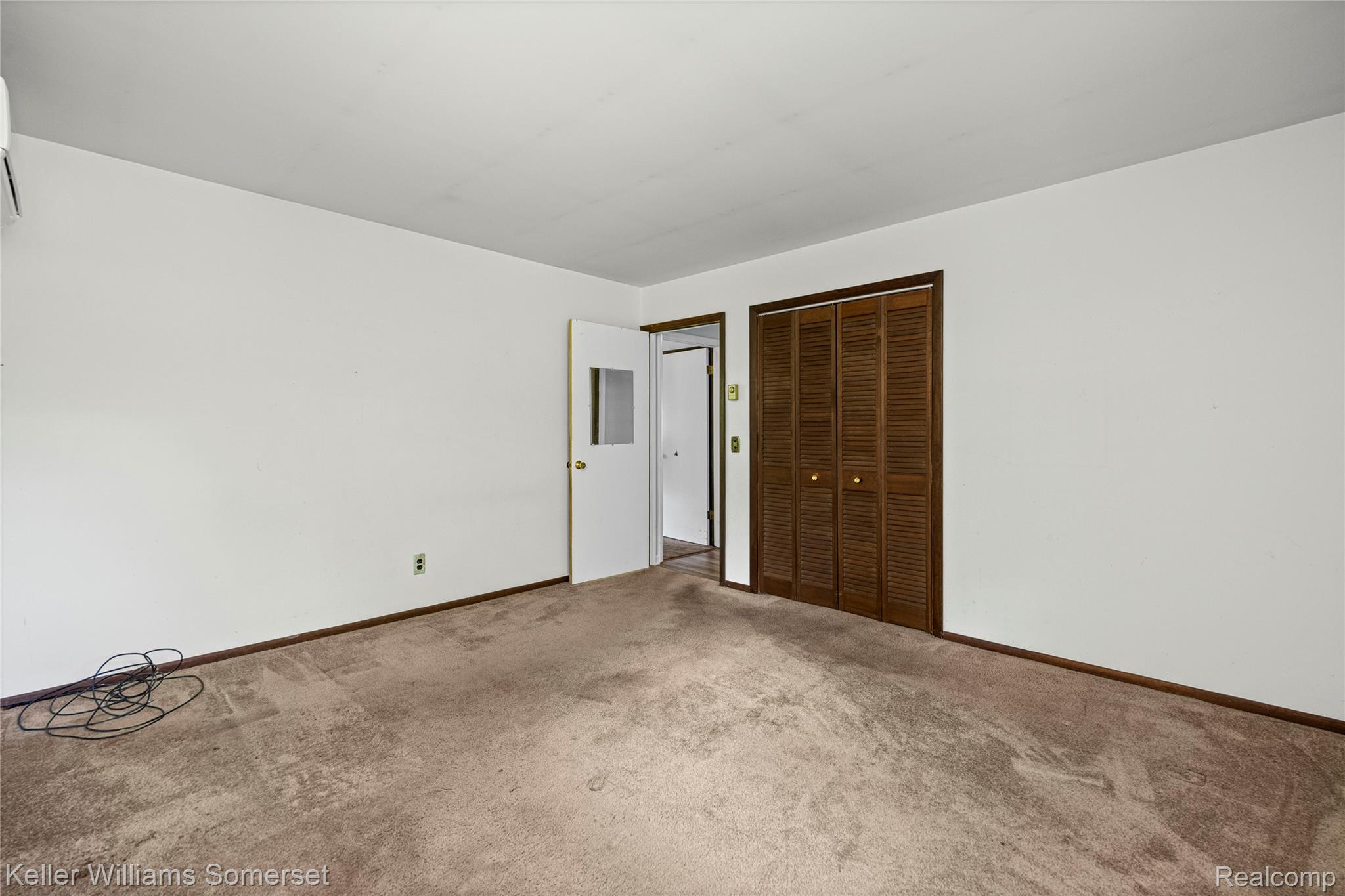 2344 Rochester Road Leonard, MI 48367 - Photo 29 of 66 Spacious room featuring neutral carpet flooring, white walls, and dark wood trim