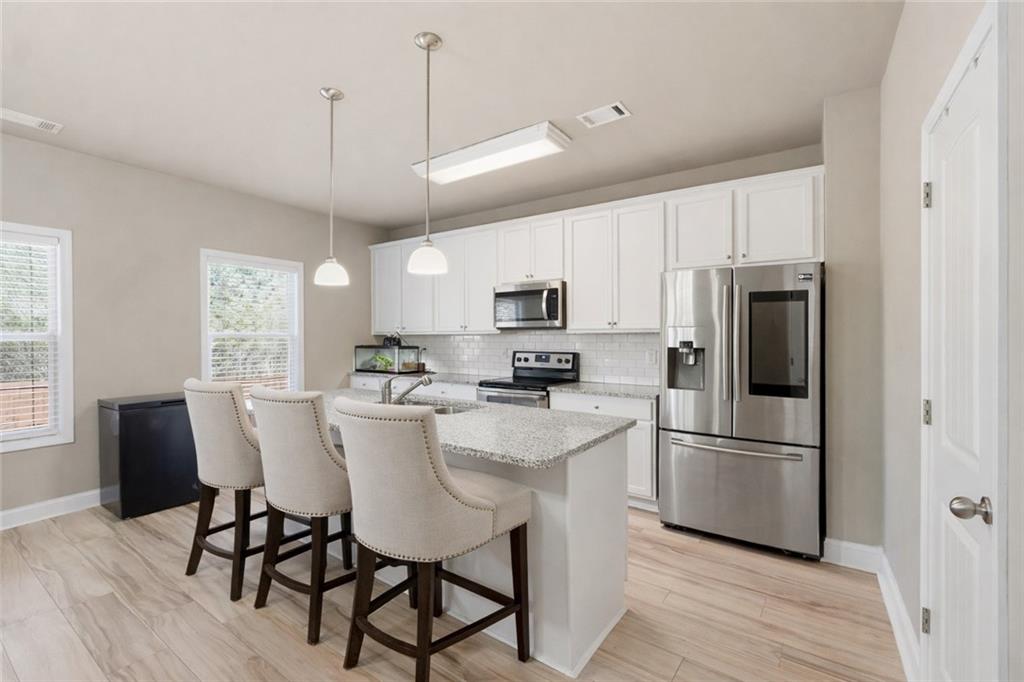 847 Wellford Avenue Jefferson, GA 30549 - Photo 2 of 33 a kitchen with stainless steel appliances granite countertop a dining table chairs refrigerator and microwave