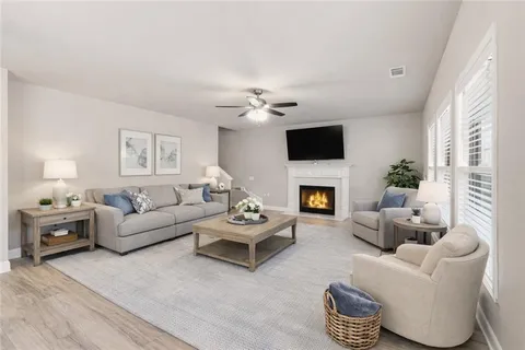 a living room with furniture a fireplace and a large window