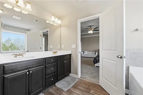 a spacious bathroom with a double vanity sink a large mirror and a shower