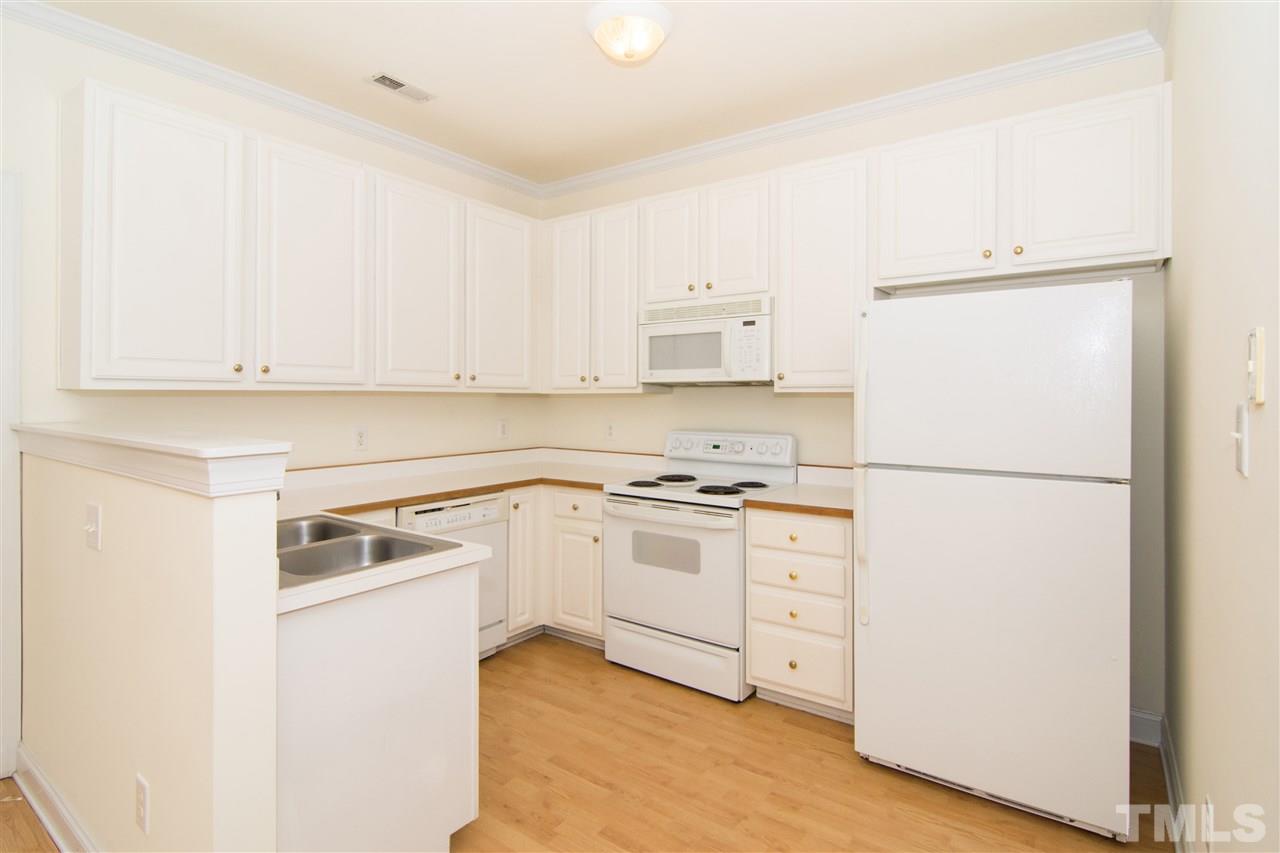 4146 Standing Rock Way Raleigh, NC 27604 - Photo 7 of 18 a kitchen with white cabinets and white stainless steel appliances