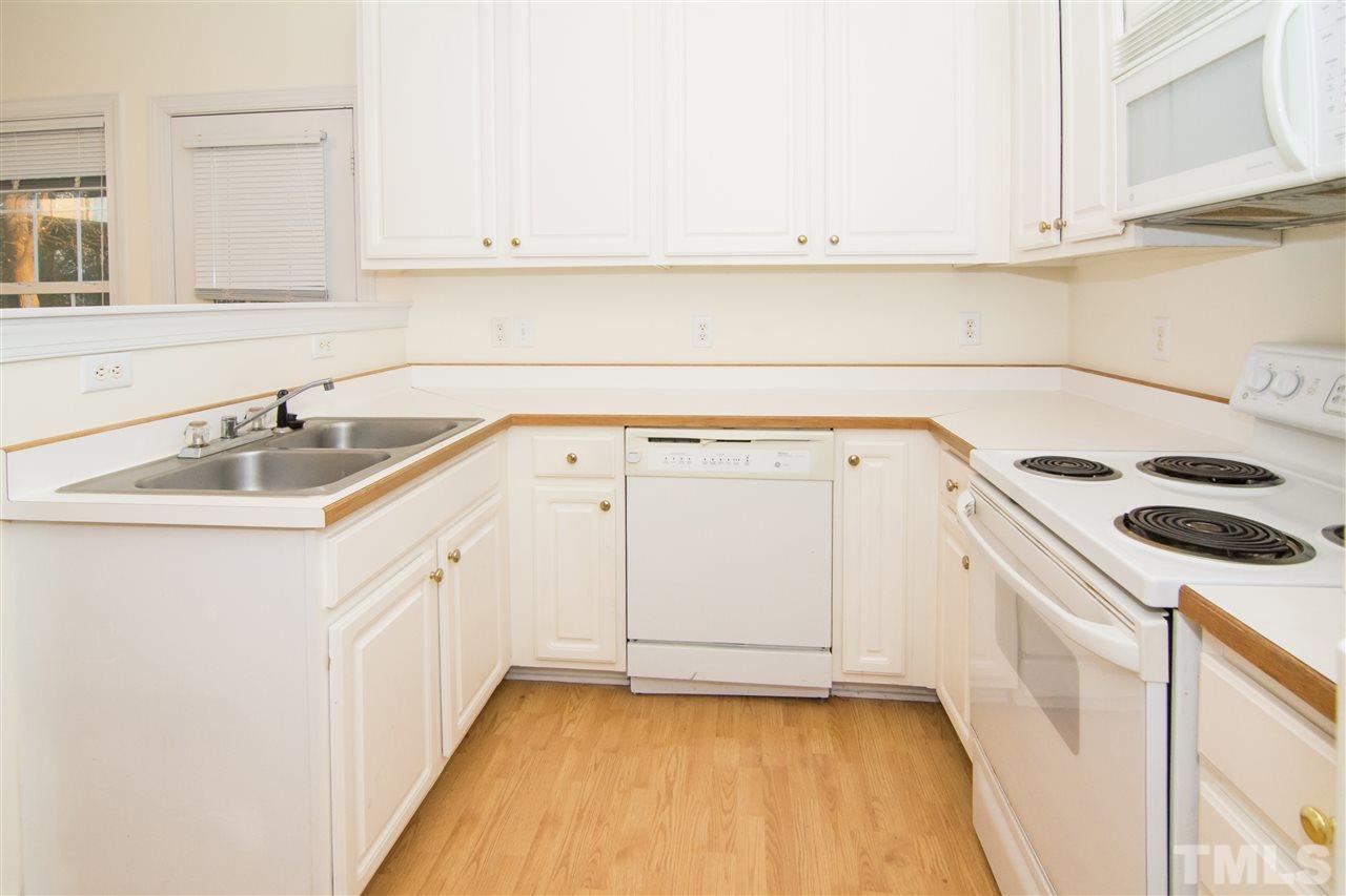 4146 Standing Rock Way Raleigh, NC 27604 - Photo 8 of 18 a kitchen with granite countertop a sink and white cabinets