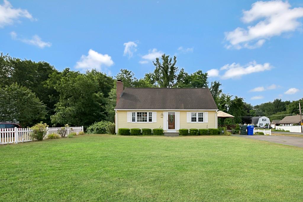 a front view of a house with a yard and trees