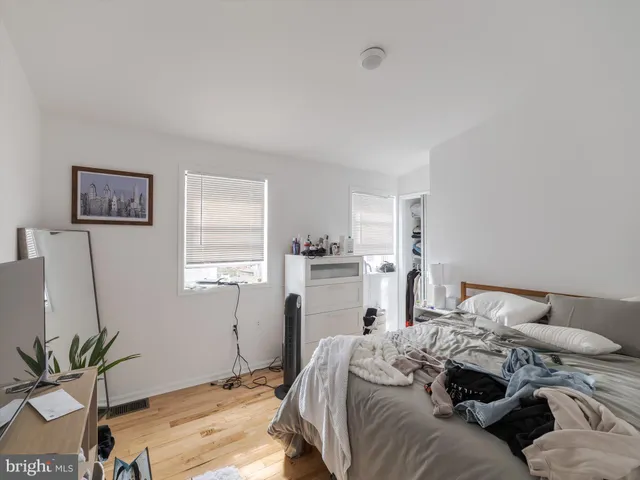 a bedroom with a bed and a painting on the wall