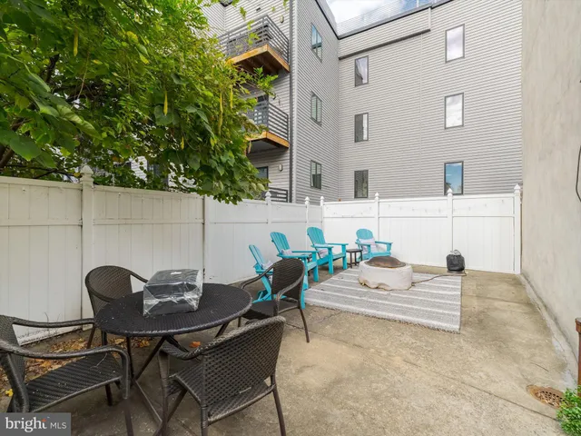a backyard of a house with fire pit and outdoor seating