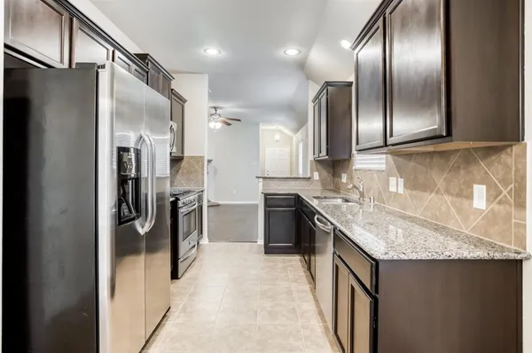 a kitchen with stainless steel appliances granite countertop a refrigerator and a sink
