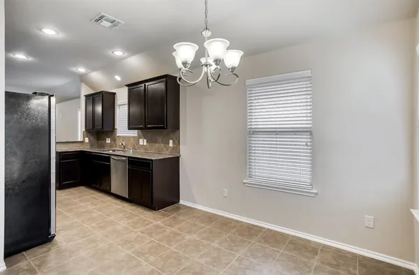 a kitchen with kitchen island granite countertop stainless steel appliances cabinets a window and a sink