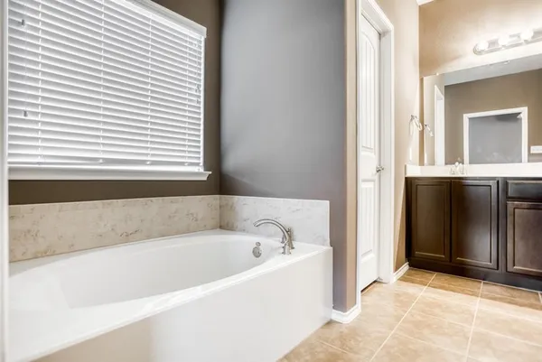 a white bath tub sitting in a bathroom next to a window