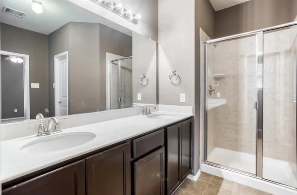 a bathroom with a granite countertop sink a mirror and a shower