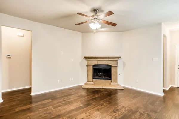 an empty room with a fireplace and wooden floor