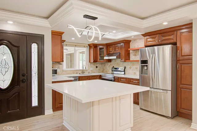 a kitchen with stainless steel appliances granite countertop a refrigerator a sink a stove and island
