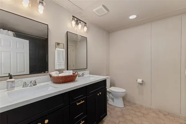 a bathroom with a double vanity sink toilet and a mirror
