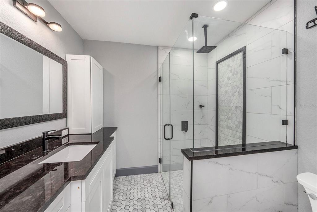 1713 West St Isabel Street Tampa, FL 33607 - Photo 18 of 25 a bathroom with a double vanity sink a mirror and a shower