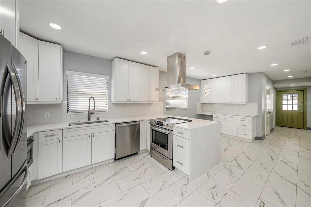 1713 West St Isabel Street Tampa, FL 33607 - Photo 6 of 25 a kitchen with stainless steel appliances granite countertop a sink and a stove top oven