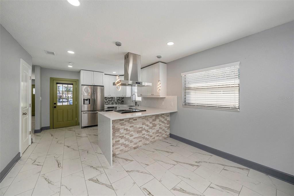 1713 West St Isabel Street Tampa, FL 33607 - Photo 7 of 25 a large kitchen with stainless steel appliances kitchen island granite countertop a sink and cabinets