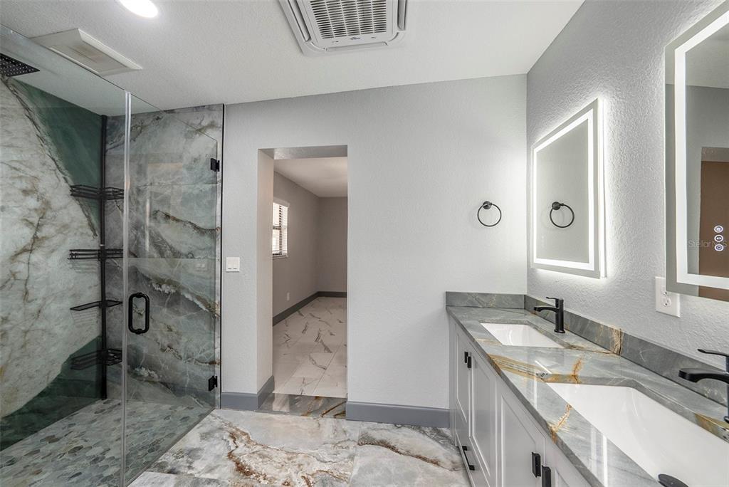 1713 West St Isabel Street Tampa, FL 33607 - Photo 9 of 25 a spacious bathroom with a granite countertop sink a mirror and shower